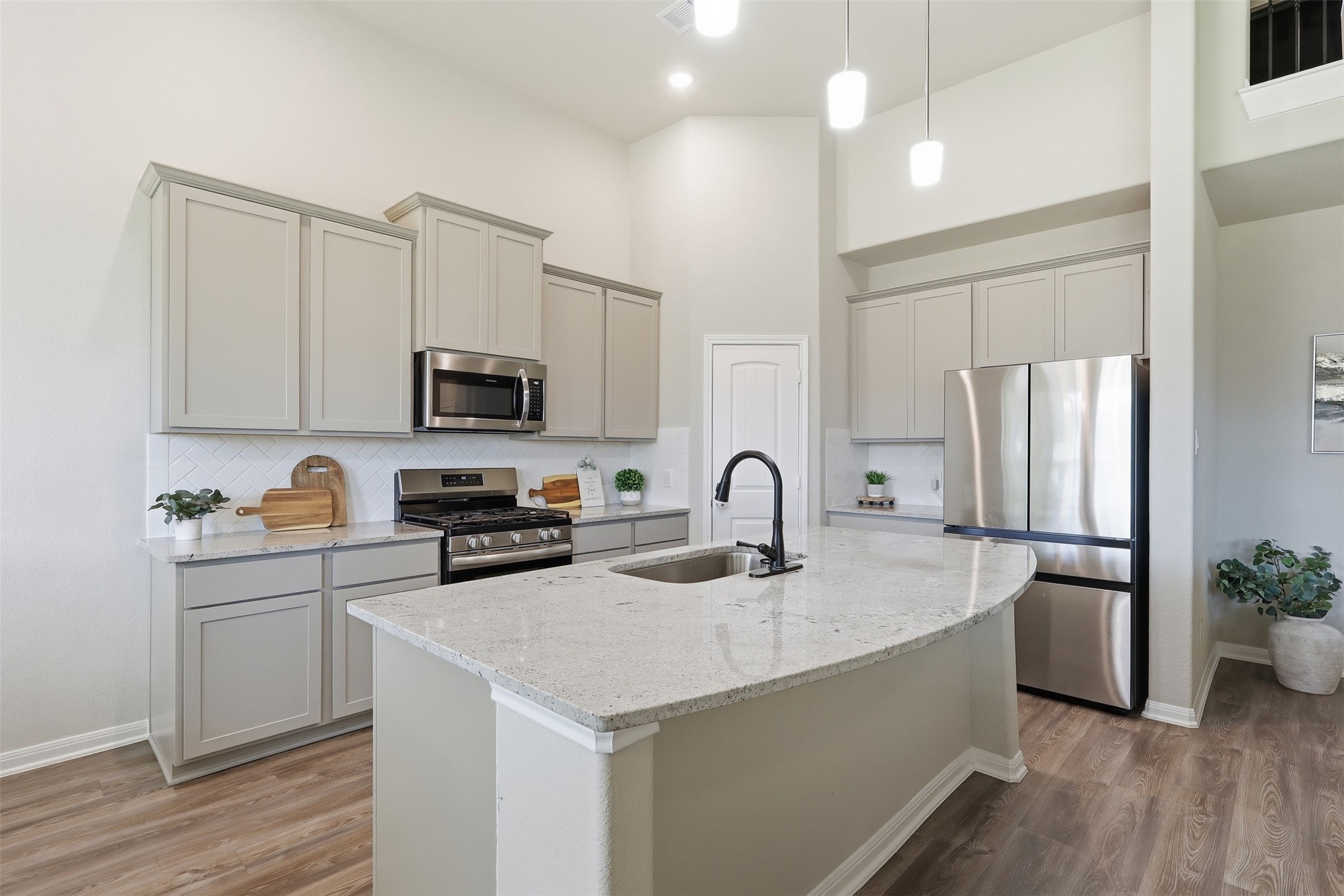 6310 Fawn Path Drive Conroe, TX 77303 - Photo 16 of 41 Stunning kitchen with upgraded granite countertops and backsplash, stainless steel appliances, modern cabinetry, and a large island, perfect for gathering and entertaining.