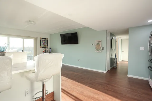 a living room with furniture a flat screen tv and a floor to ceiling window