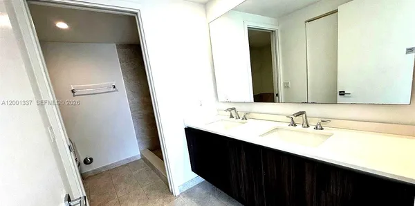 a bathroom with a double vanity sink and mirror