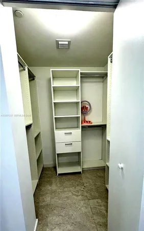 a view of walk in closet with clothes