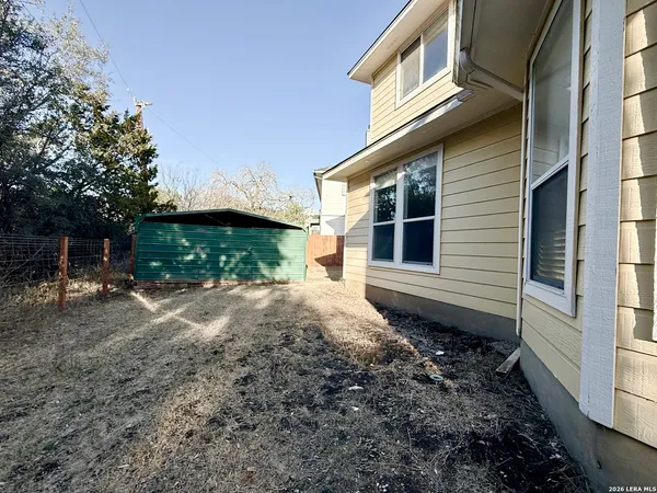 a backyard of a house with plants and trees