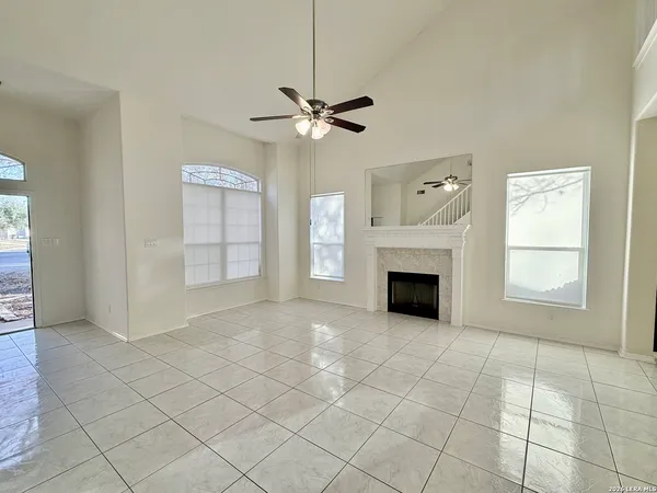 an empty room with windows and fireplace