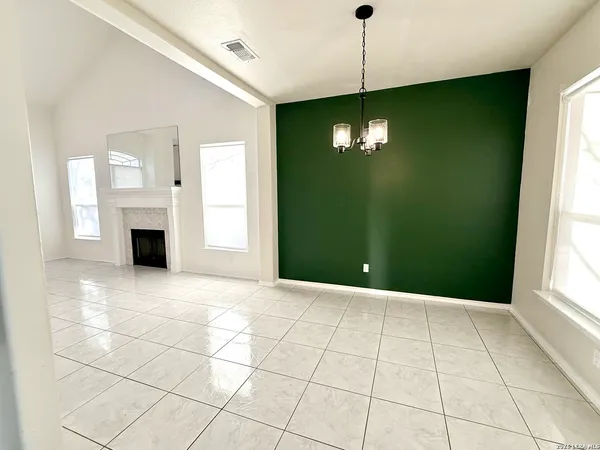 a view of a livingroom with a chandelier fan and windows