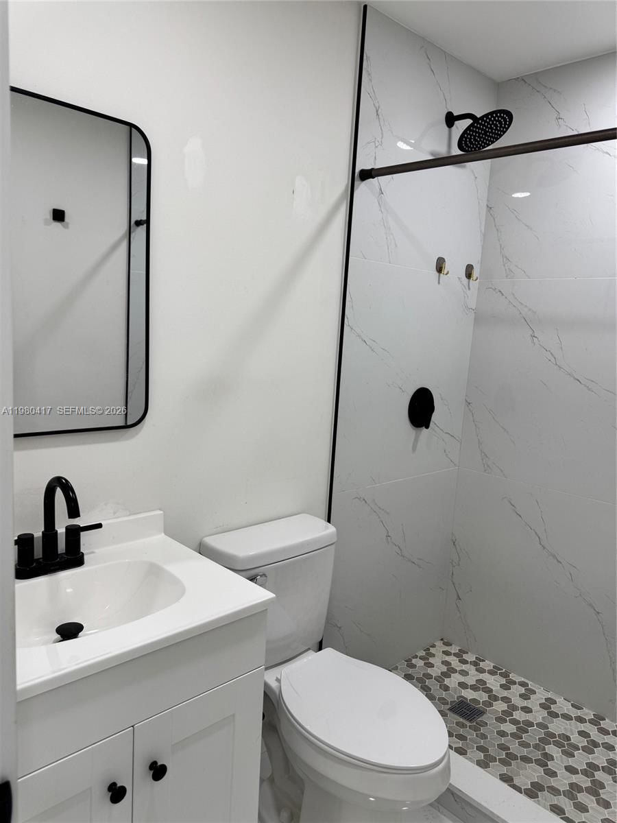 9425 Southwest 4th Lane, Unit 9425 Miami, FL 33174 - Photo 12 of 14 a bathroom with a sink a toilet a mirror and shower