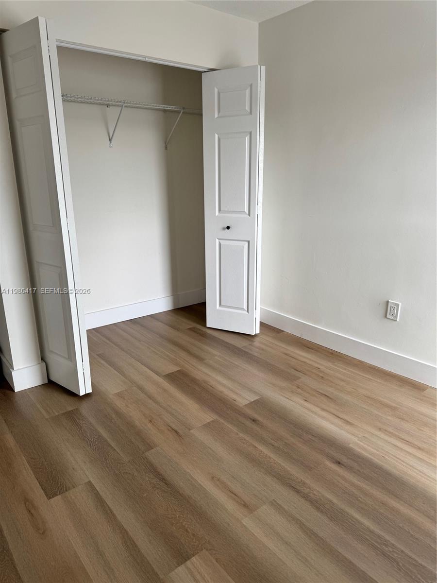 9425 Southwest 4th Lane, Unit 9425 Miami, FL 33174 - Photo 13 of 14 an empty room with wooden floor and closet
