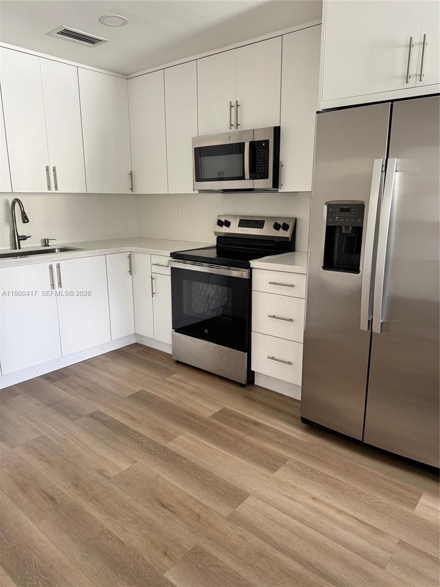9425 Southwest 4th Lane, Unit 9425 Miami, FL 33174 - Photo 7 of 14 a kitchen with granite countertop a refrigerator stove and microwave