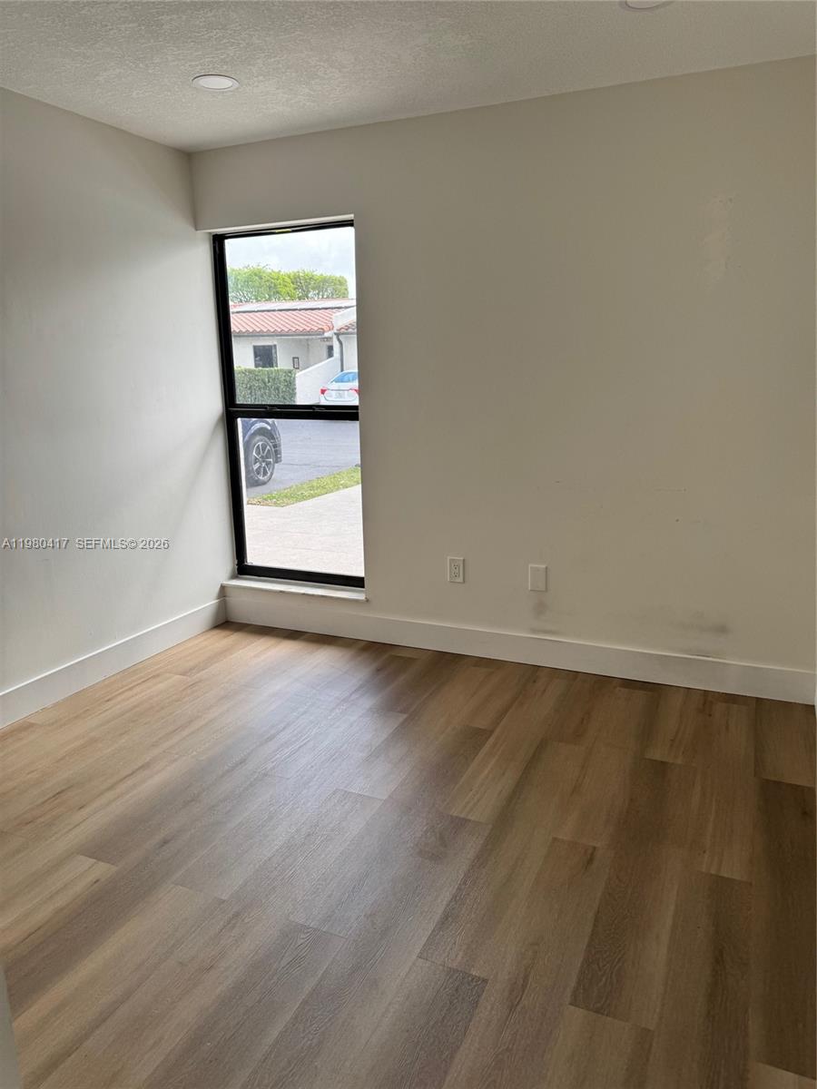 9425 Southwest 4th Lane, Unit 9425 Miami, FL 33174 - Photo 10 of 14 an empty room with wooden floor and windows