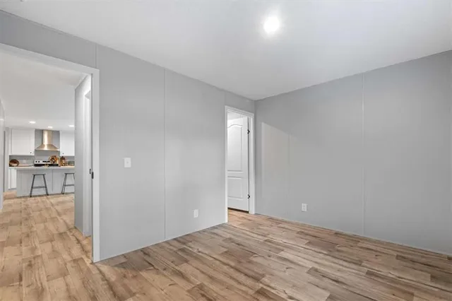 a view of a room with wooden floor and a kitchen