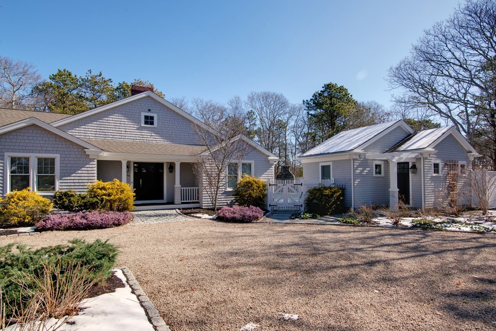 84 Troon Place Mashpee, MA 02649 - Photo 3 of 30 a front view of a house with a yard and potted plants