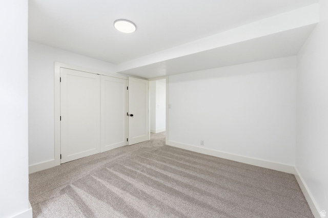 871 Bonita Way Centerville, UT 84014 - Photo 32 of 61 Spacious room with light gray carpet, white baseboards, and a flush-mount ceiling light fixture