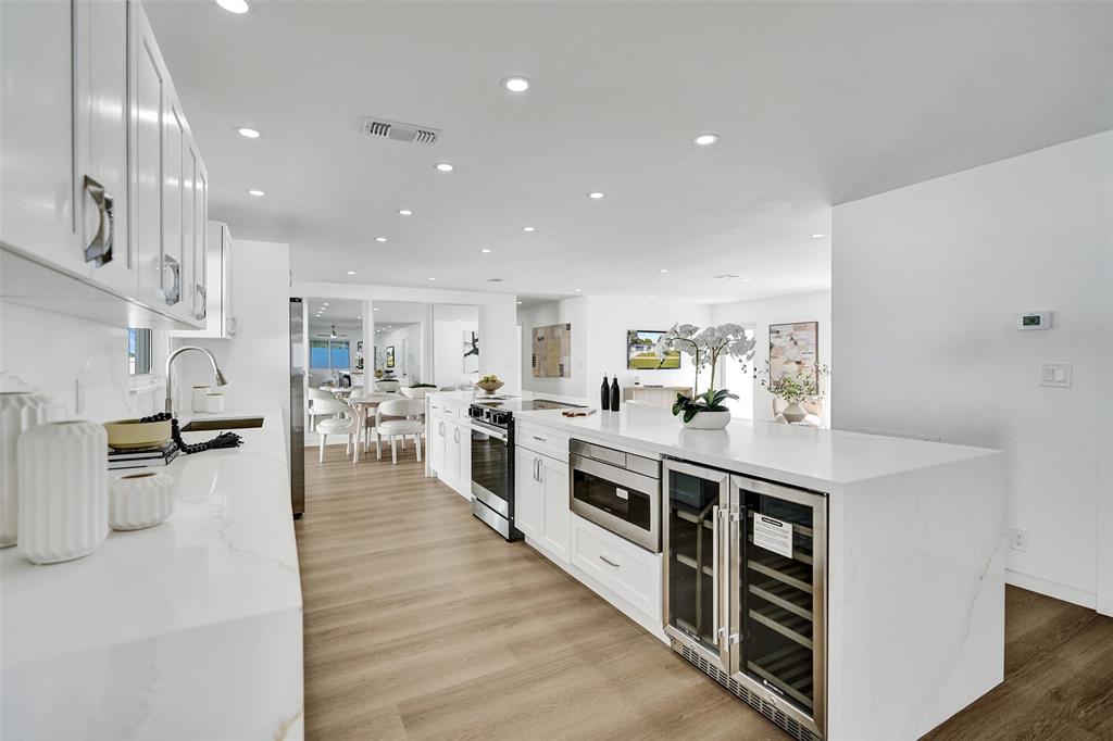 699 Northeast 70th Street Boca Raton, FL 33487 - Photo 14 of 60 a large white kitchen with stainless steel appliances