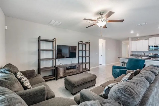 a dining room with furniture potted plants and a chandelier