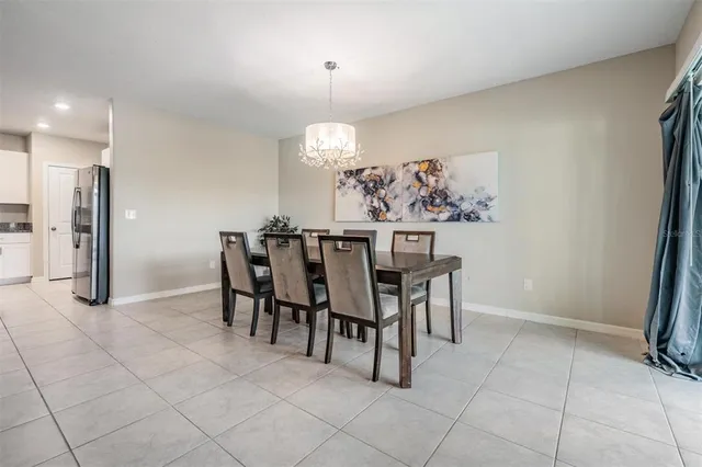 a view of an empty room with a chandelier fan