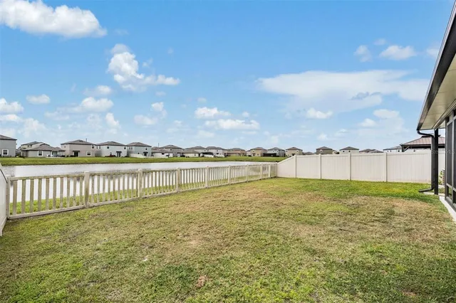 a view of a house with pool and a yard
