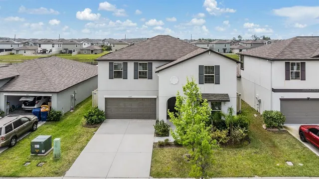 a kitchen with stainless steel appliances granite countertop a refrigerator a stove a sink a dining table and chairs