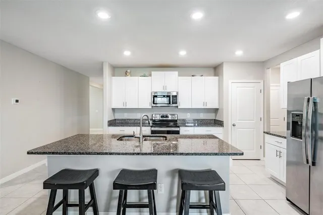 a living room with furniture and a view of kitchen