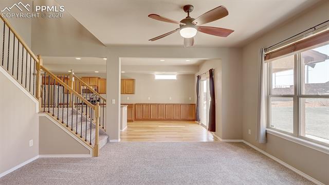 2316 Rusty Ridge Court Colorado Springs, CO 80921 - Photo 10 of 46 Large Living room with a beautiful staircase and attached to an eat in kitchen.