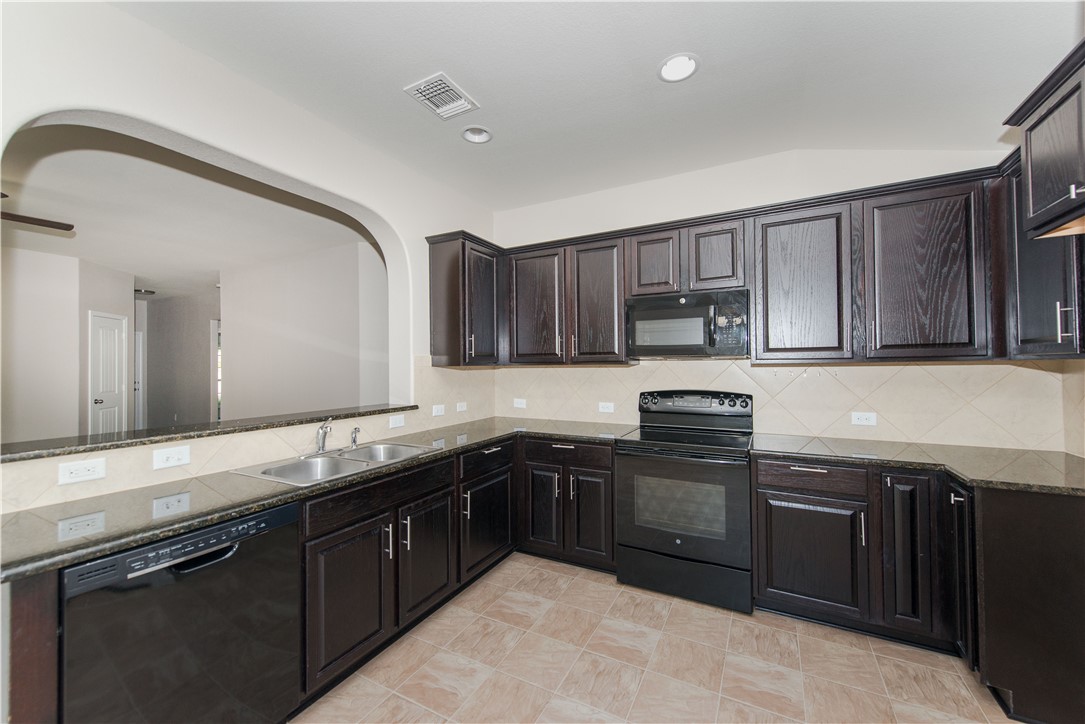 1007 Plateau Trail Georgetown, TX 78626 - Photo 7 of 32 a kitchen with granite countertop stainless steel appliances and sink