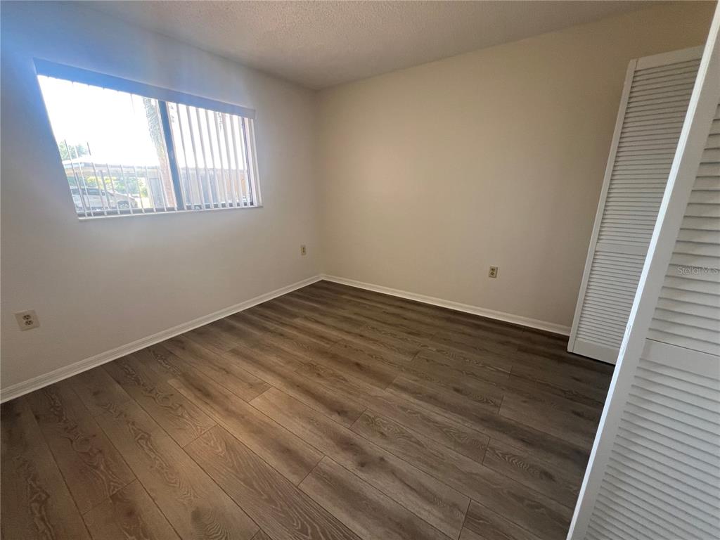 1330 Rio De Janeiro Avenue, Unit 5 Punta Gorda, FL 33983 - Photo 10 of 17 a view of an empty room with wooden floor and a window