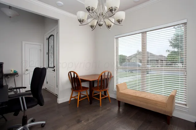 a view of a workspace with furniture and a window