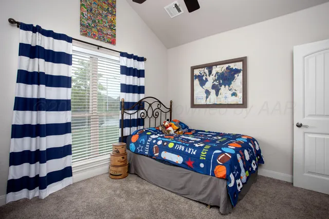 a bedroom with a bed and a painting on the wall