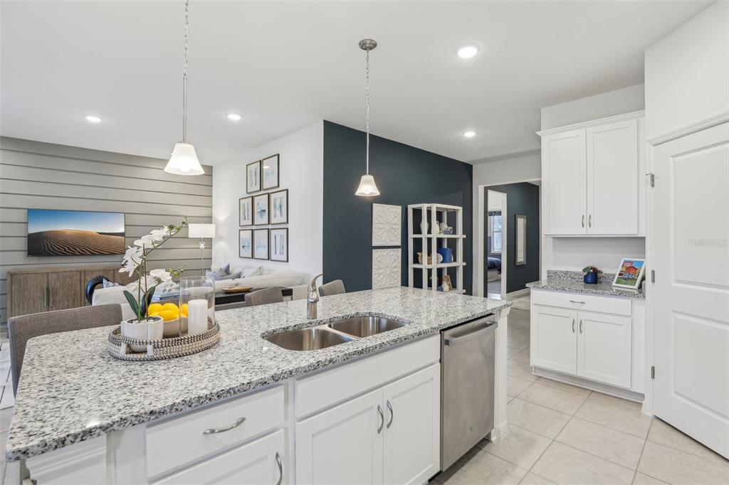 9600 Starling Loop Leesburg, FL 34788 - Photo 6 of 36 a kitchen with stainless steel appliances granite countertop a sink refrigerator and cabinets