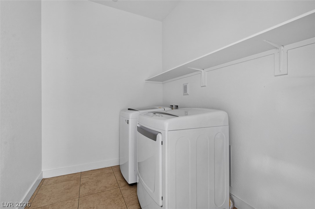 1100 East Sunset Road Henderson, NV 89011 - Photo 25 of 58 Functional utility room with tiled flooring and ample shelving, ready for all your laundry needs.