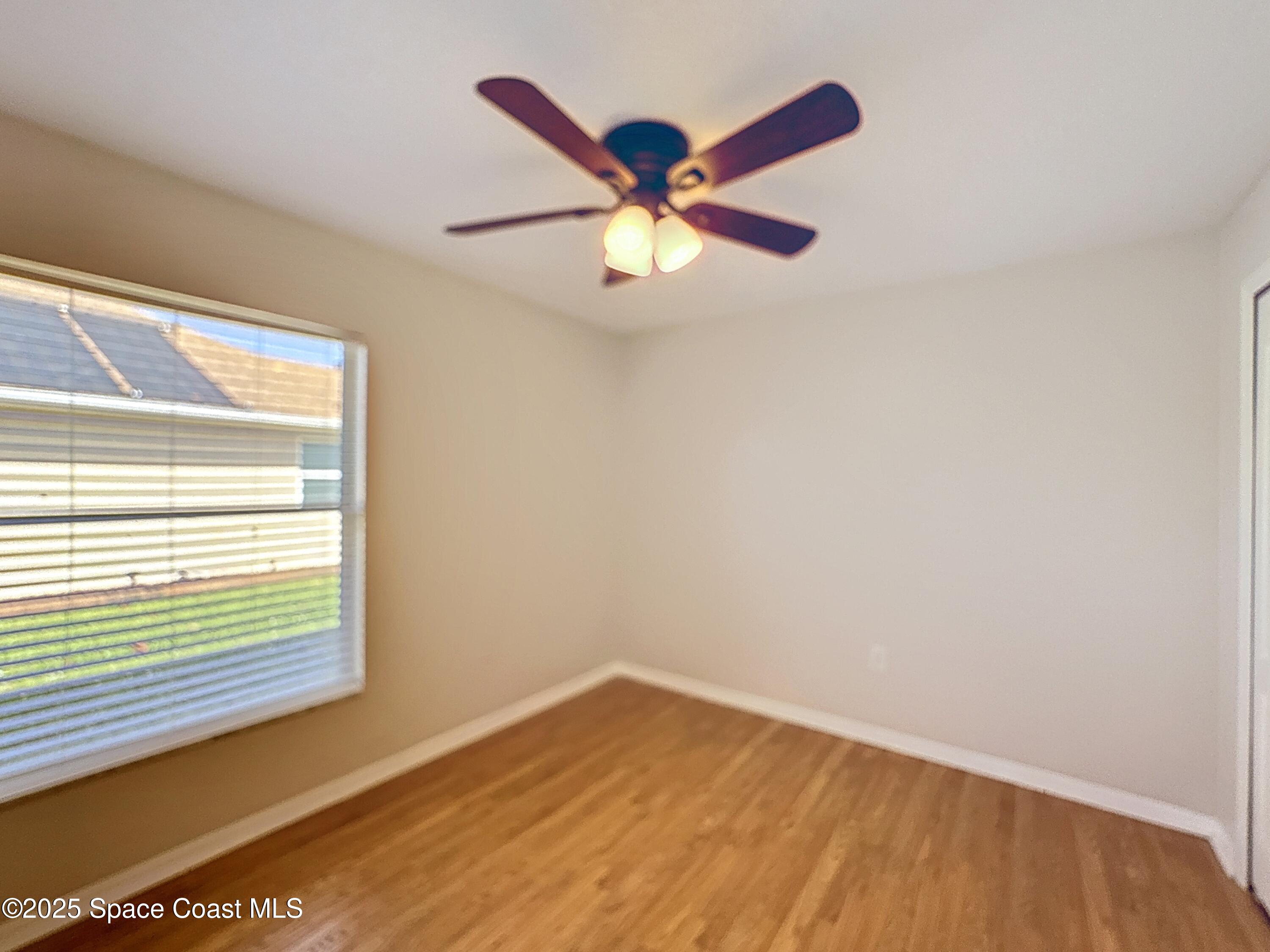 7370 Joshua Place Cocoa, FL 32927 - Photo 13 of 21 a view of an empty room with window and wooden floor
