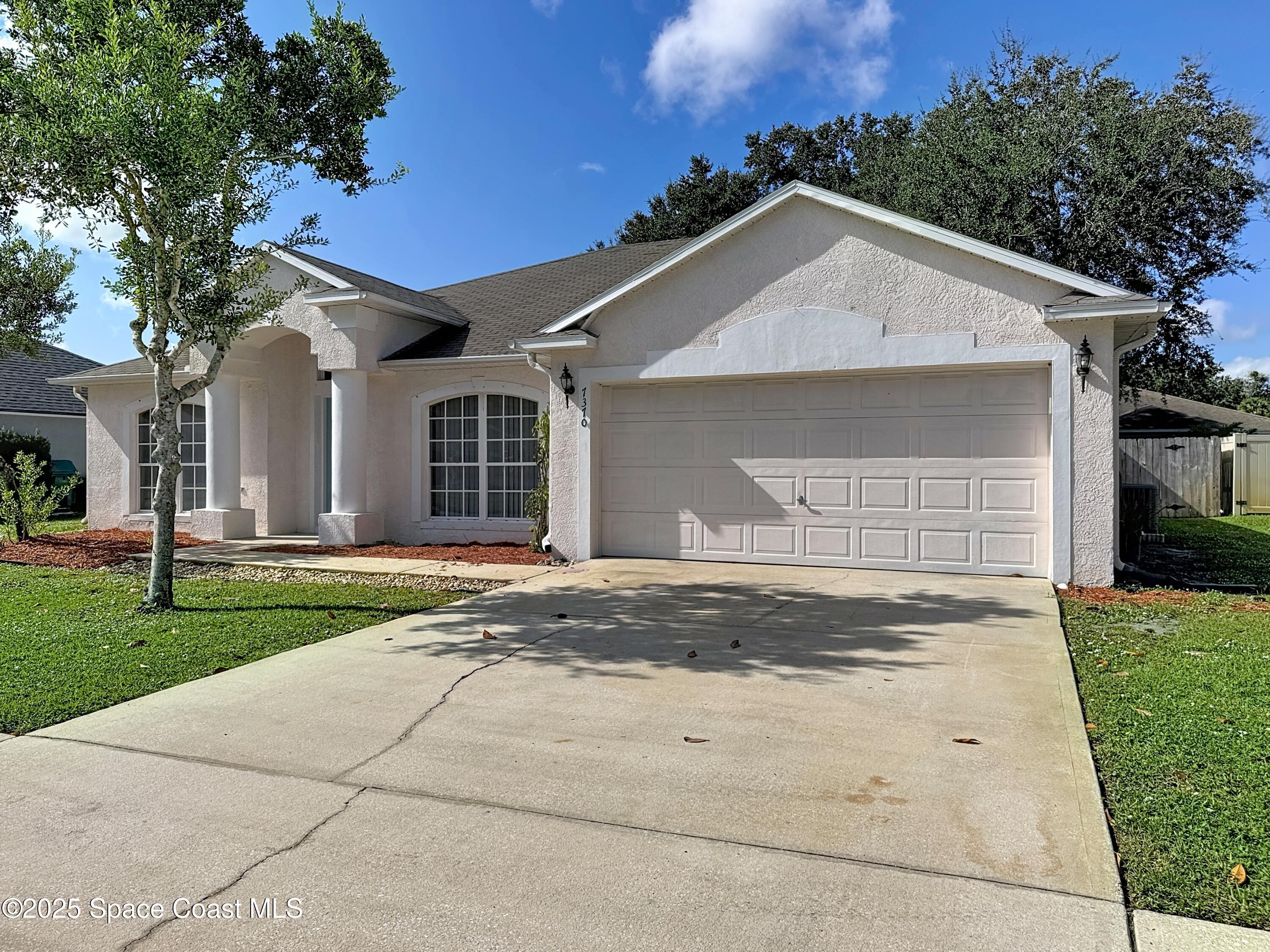 7370 Joshua Place Cocoa, FL 32927 - Photo 20 of 21 a view of garage yard and tree