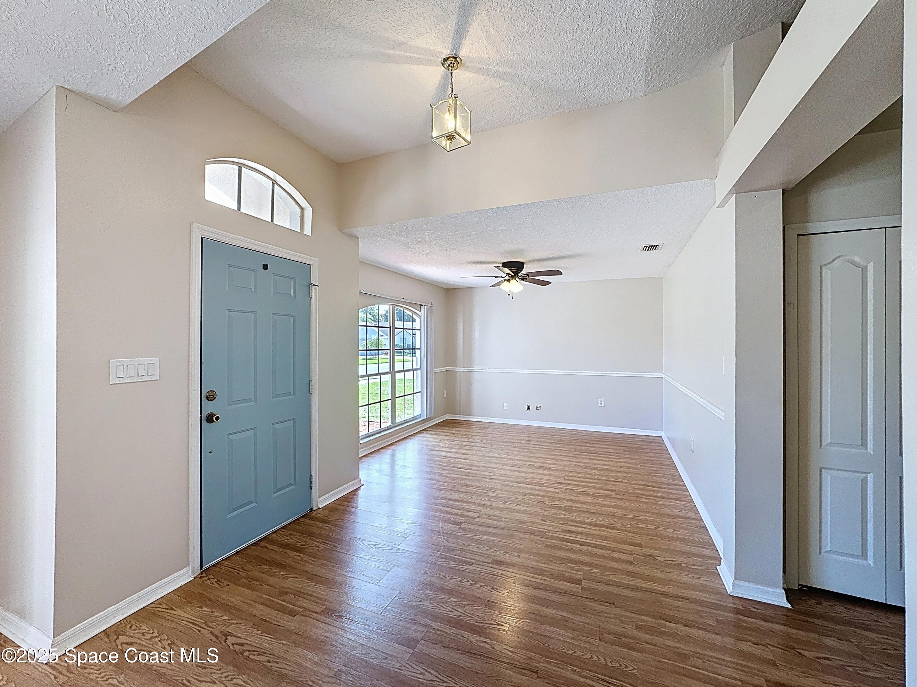 7370 Joshua Place Cocoa, FL 32927 - Photo 2 of 21 a view of an empty room with wooden floor and a window