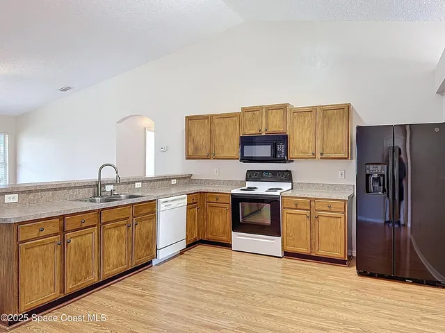 a kitchen with granite countertop stainless steel appliances and wooden cabinets
