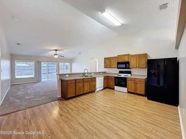 a large kitchen with stainless steel appliances wooden floors and wooden cabinets