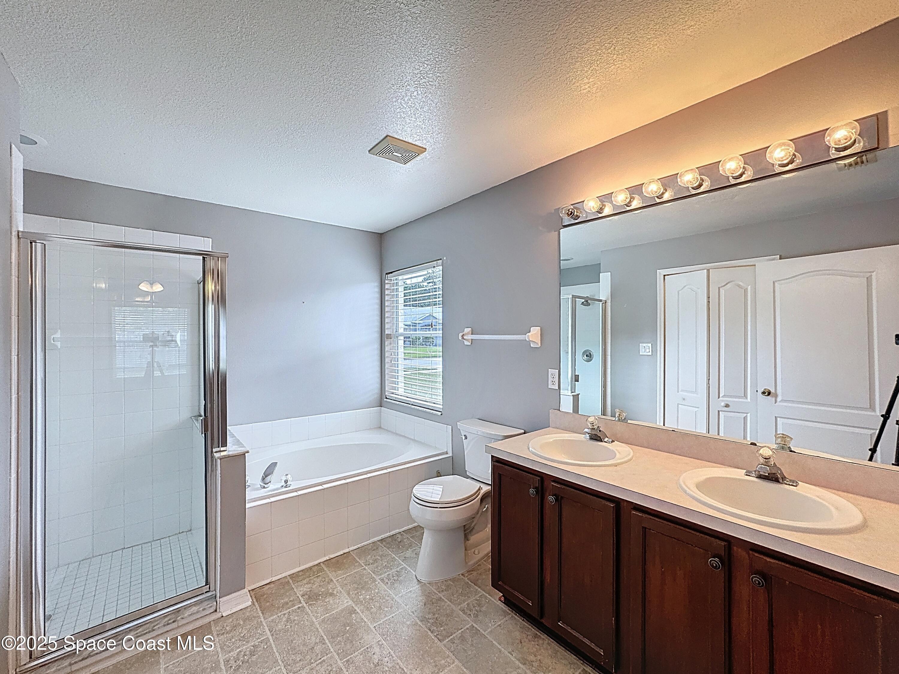 7370 Joshua Place Cocoa, FL 32927 - Photo 10 of 21 a bathroom with a double vanity sink toilet mirror and bathtub