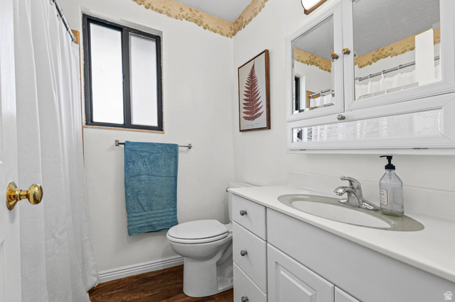 5896 South 3950th Street West Roy, UT 84067 - Photo 13 of 29 Full bathroom with vanity, curtained shower, and dark wood finished floors