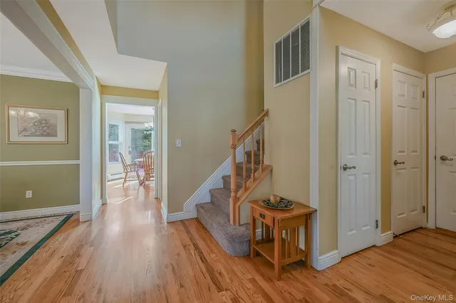 a view of a hallway with wooden floor and staircase