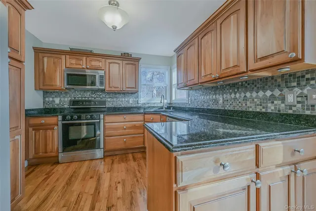 a kitchen with granite countertop a stove sink and cabinets