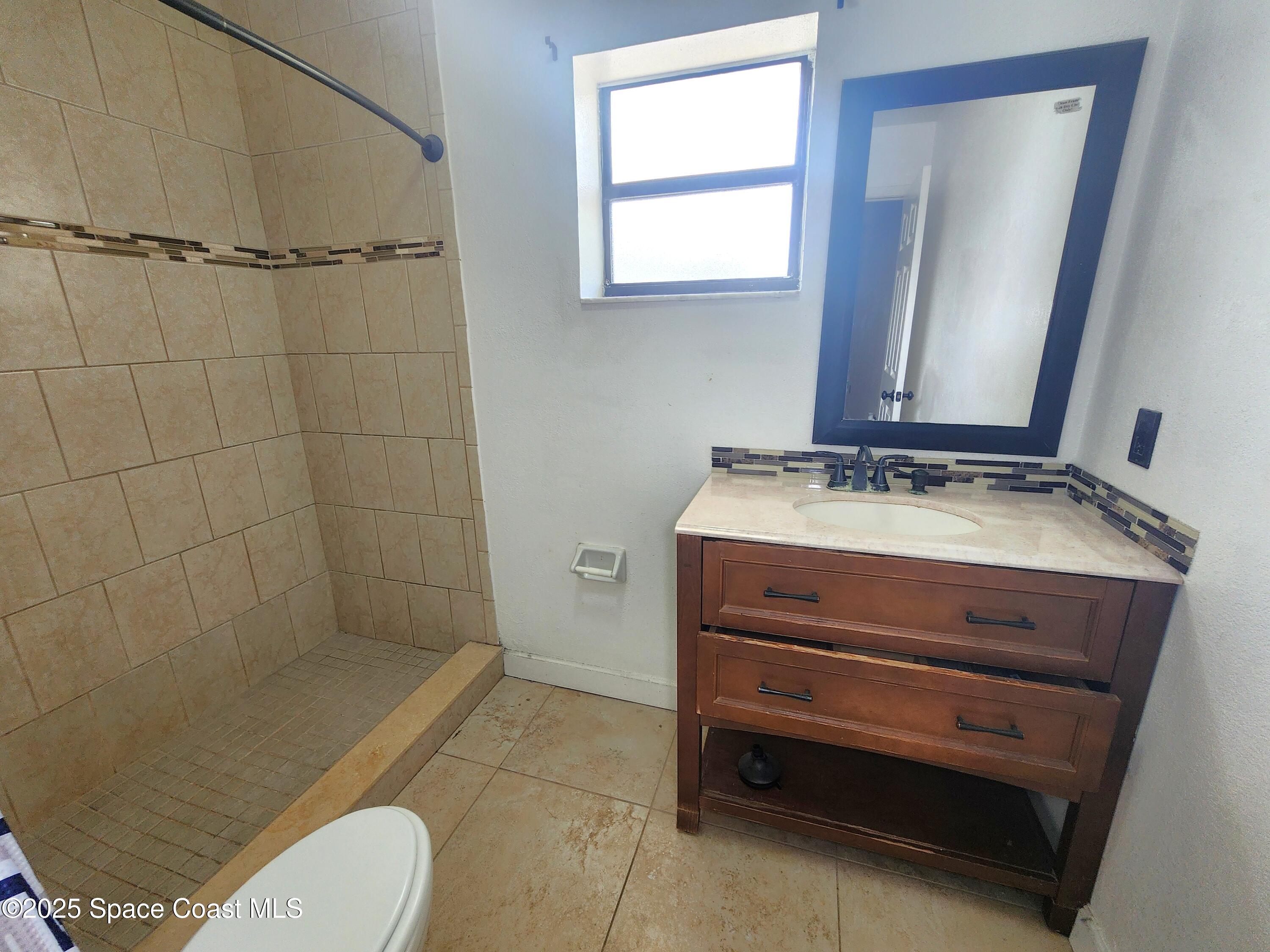 2220 Flower Tree Circle Melbourne, FL 32935 - Photo 11 of 22 a bathroom with a sink a toilet and shower