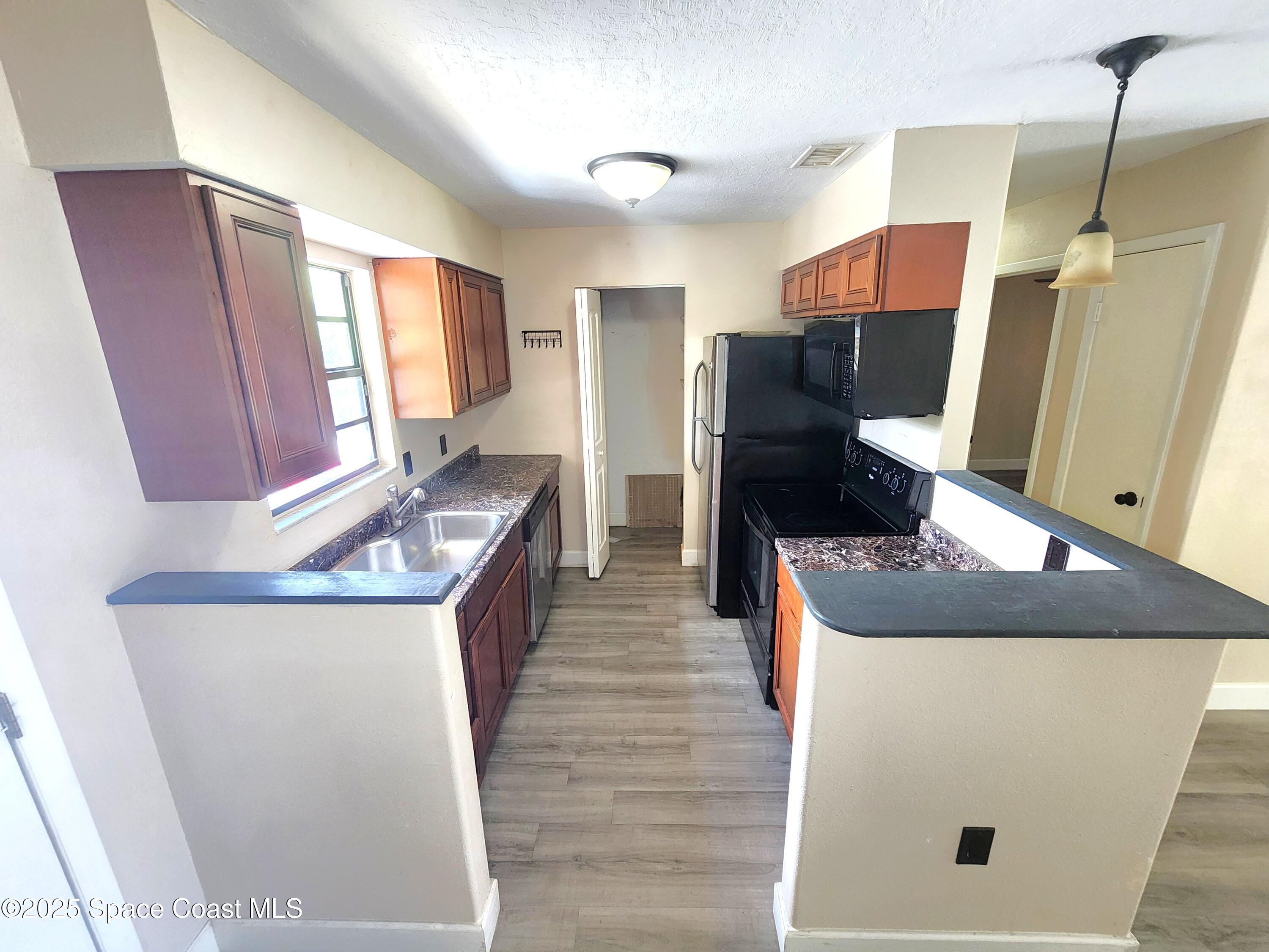 2220 Flower Tree Circle Melbourne, FL 32935 - Photo 3 of 22 a kitchen with stainless steel appliances granite countertop a refrigerator a stove a sink and dishwasher