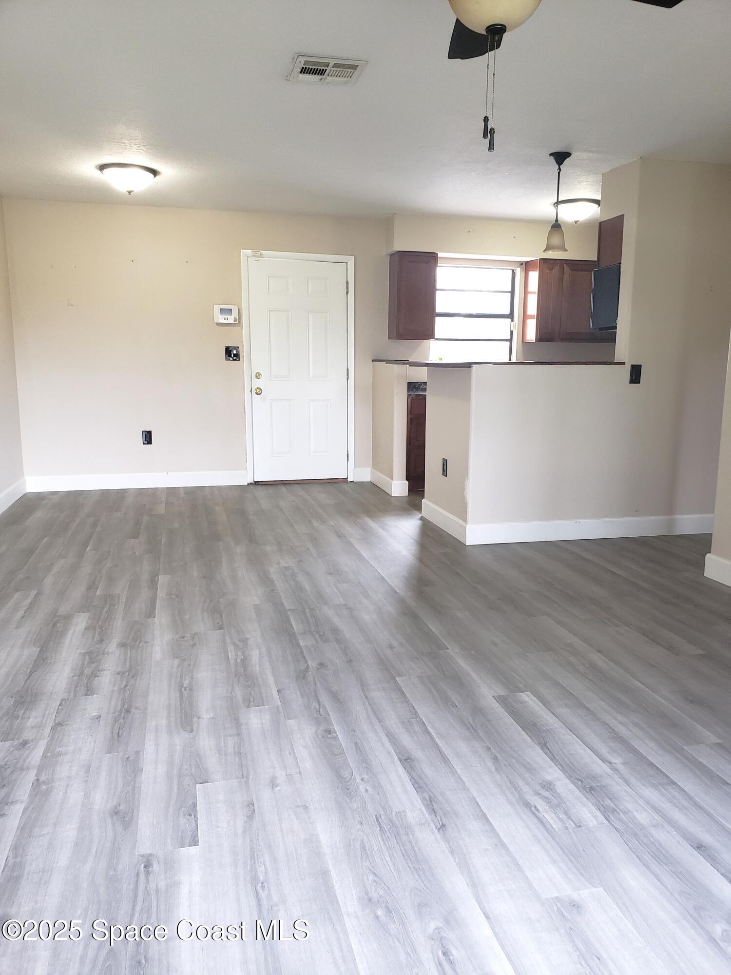 2220 Flower Tree Circle Melbourne, FL 32935 - Photo 4 of 22 an empty room with wooden floor and windows