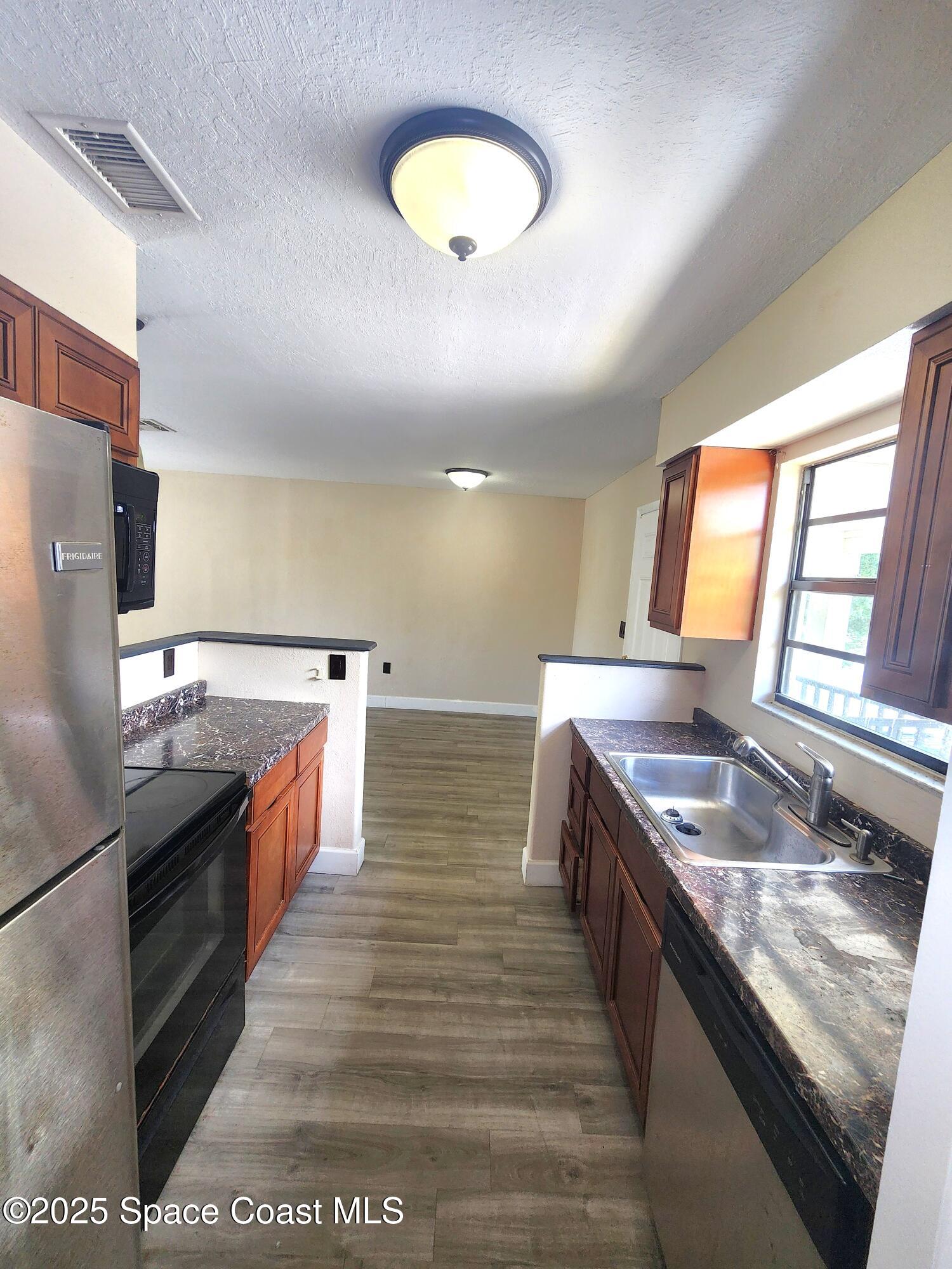 2220 Flower Tree Circle Melbourne, FL 32935 - Photo 5 of 22 a large kitchen with stainless steel appliances granite countertop a sink and stove