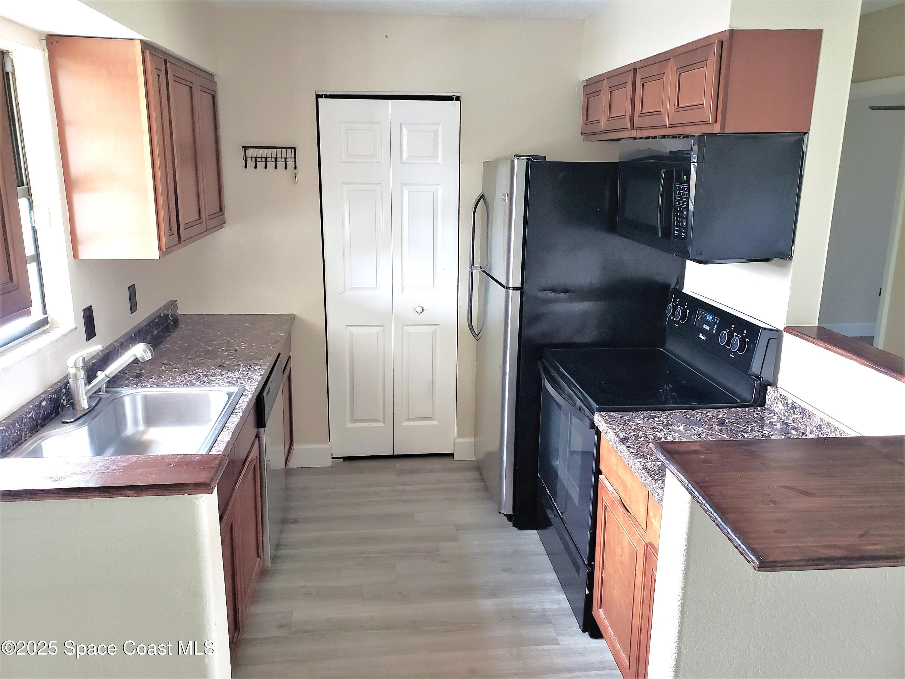 2220 Flower Tree Circle Melbourne, FL 32935 - Photo 7 of 22 a kitchen with stainless steel appliances granite countertop a sink stove and refrigerator