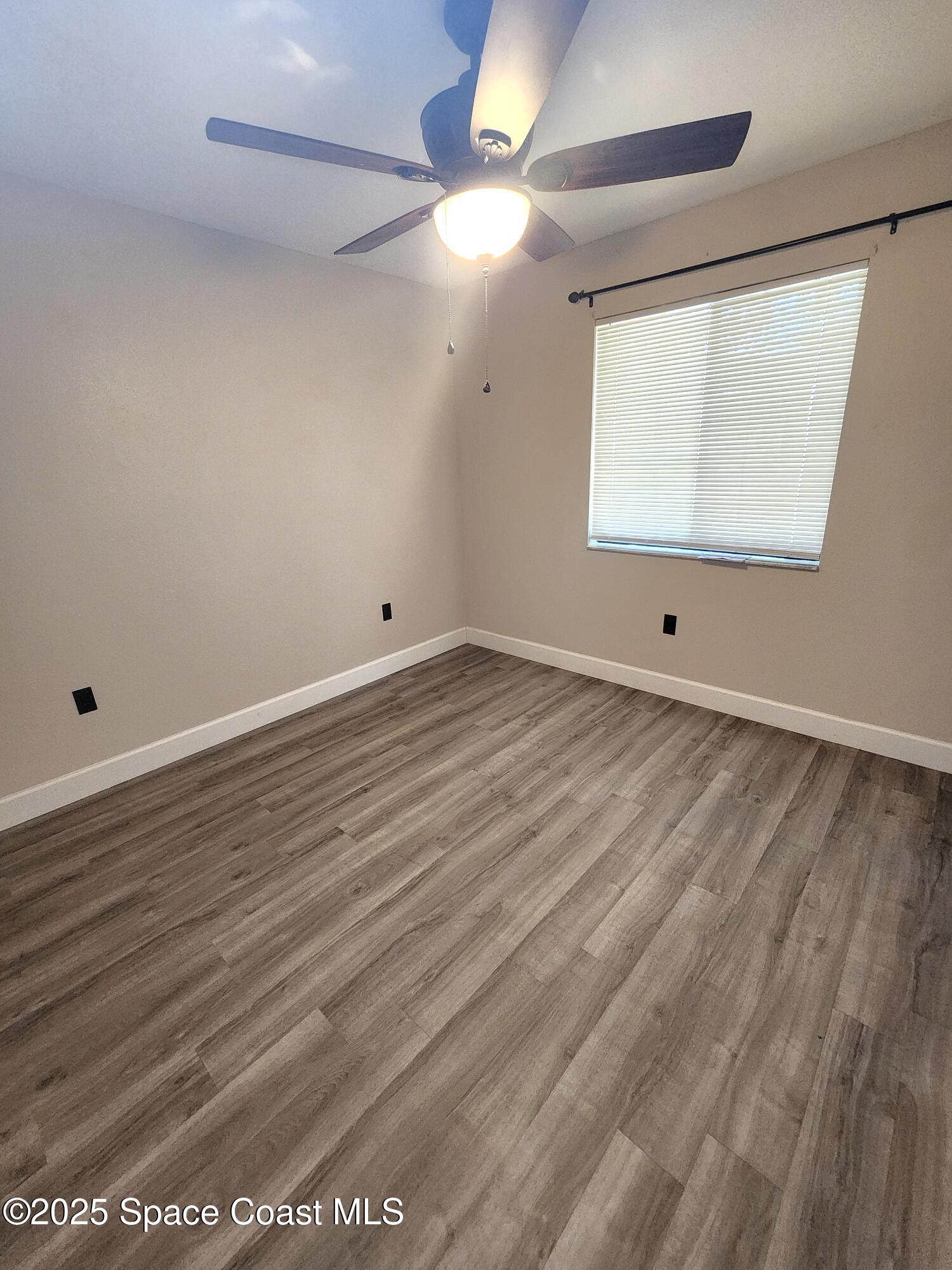 2220 Flower Tree Circle Melbourne, FL 32935 - Photo 9 of 22 an empty room with wooden floor and windows