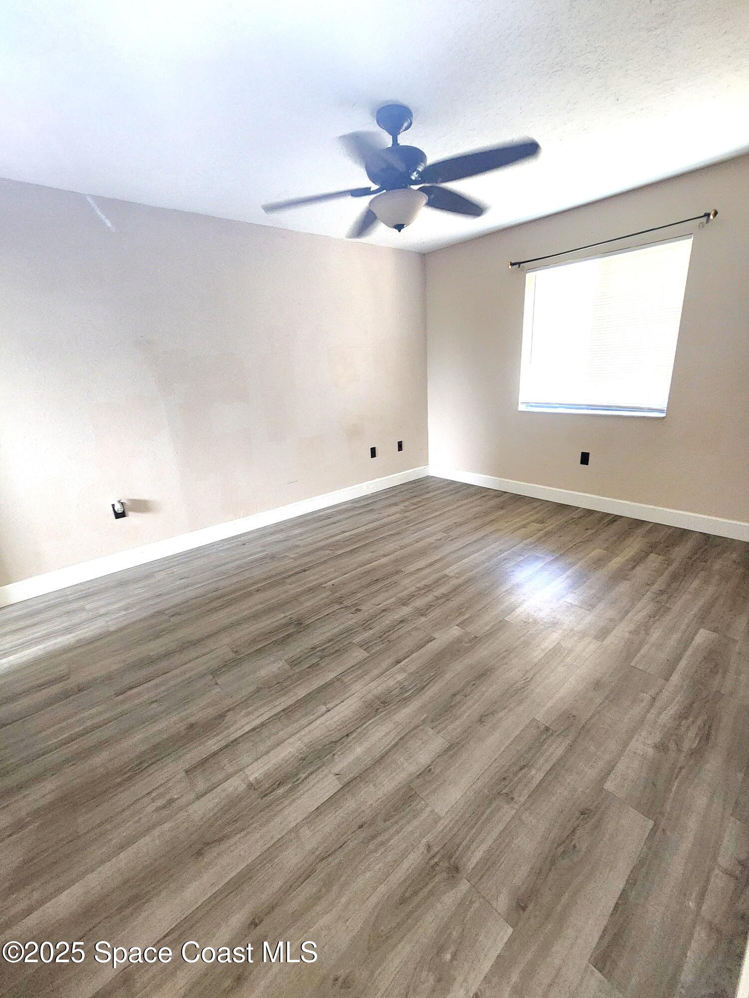 2220 Flower Tree Circle Melbourne, FL 32935 - Photo 10 of 22 an empty room with wooden floor and windows