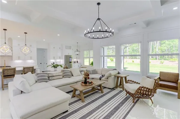 a living room with furniture chandelier and a window