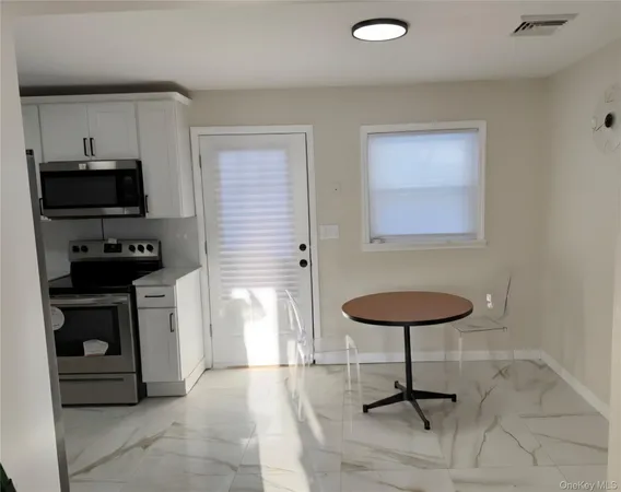 a kitchen with stainless steel appliances a stove a sink cabinets and a refrigerator