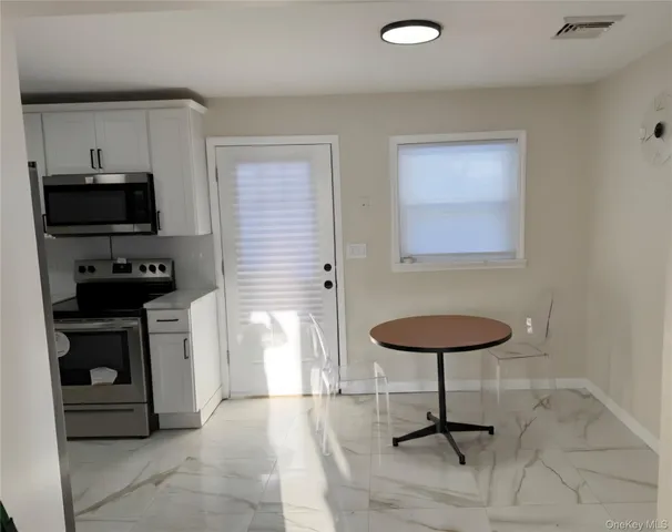 a kitchen with stainless steel appliances a stove a sink cabinets and a refrigerator