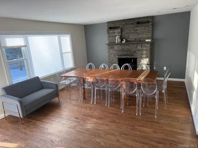 a living room with furniture a wooden floor and next to a window