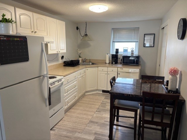 189 River Street, Unit 6 Waltham, MA 02453 - Photo 3 of 9 a kitchen with white cabinets and white appliances