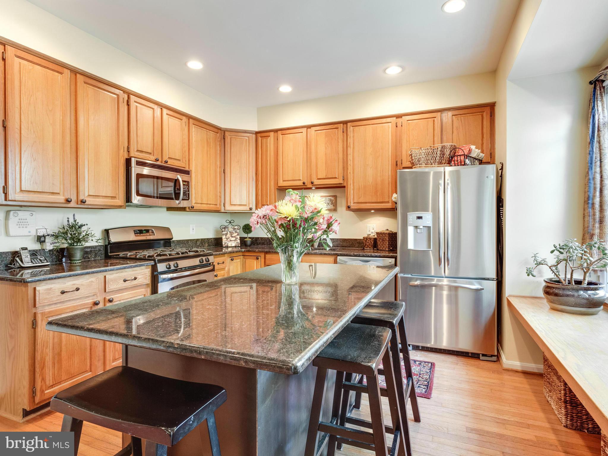 1215 Weatherstone Court Reston, VA 20194 - Photo 9 of 30 a kitchen with stainless steel appliances granite countertop a stove refrigerator and a microwave
