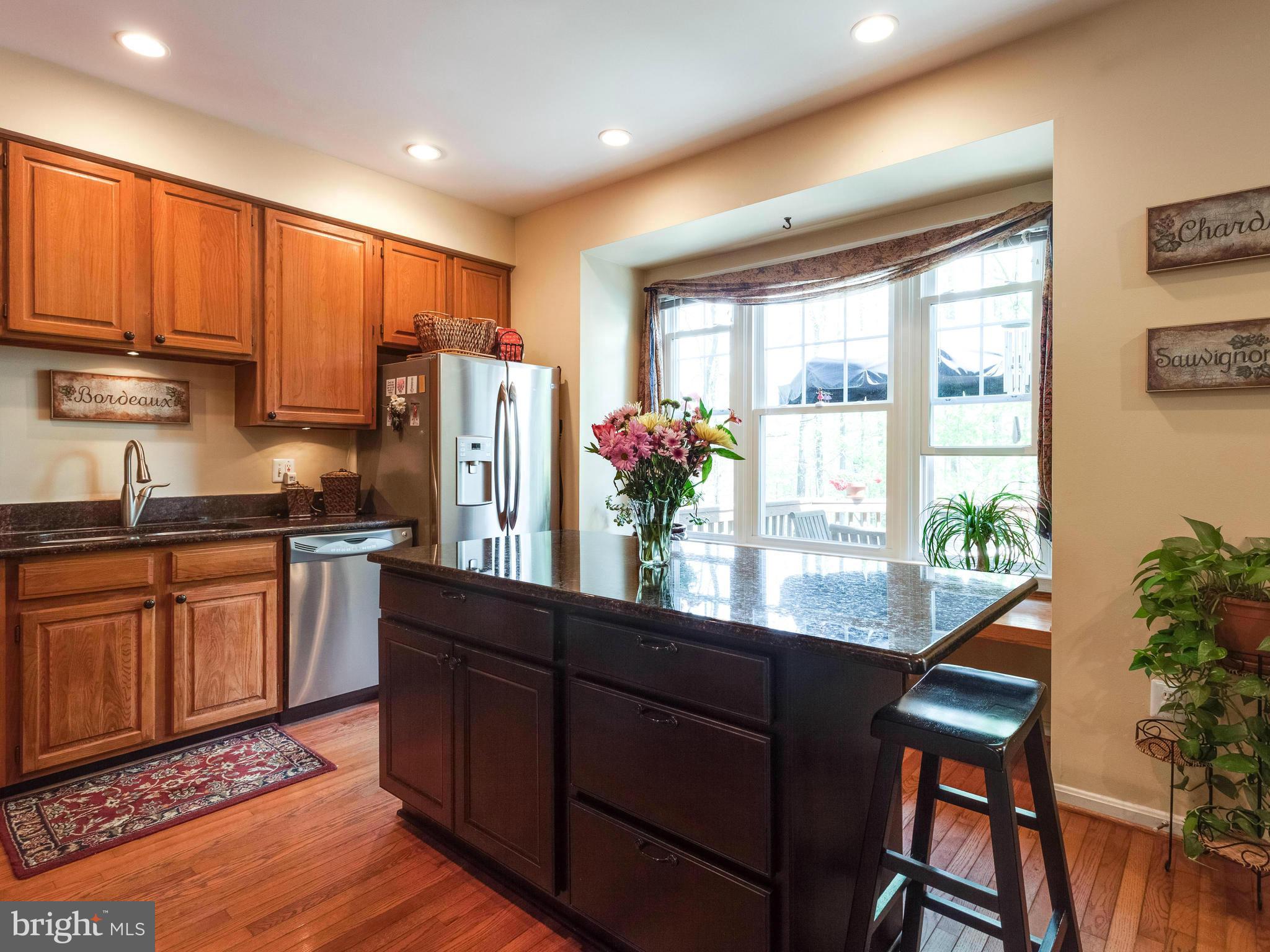 1215 Weatherstone Court Reston, VA 20194 - Photo 10 of 30 a kitchen with stainless steel appliances granite countertop sink microwave and wooden floor